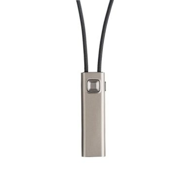 A slim, rectangular metallic device with a button near the top hangs from a black cord, resembling the Widex COM-DEX accessory.